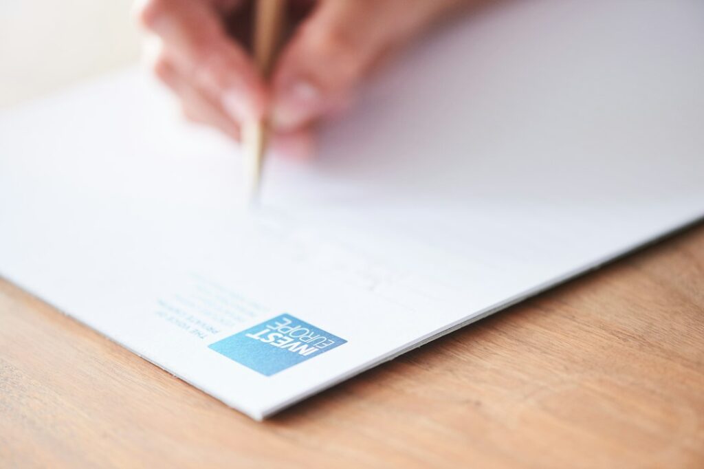 Manos tomando notas sobre documentos impresos en una mesa de trabajo