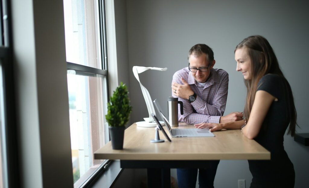 Dos personas conversando sobre documentos en una oficina sencilla de Bogotá